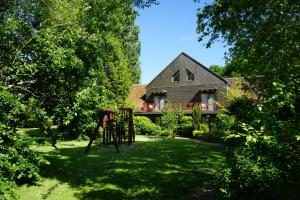uma casa com um quintal com um parque infantil em frente em Domaine de L'Arbrelle em Amboise