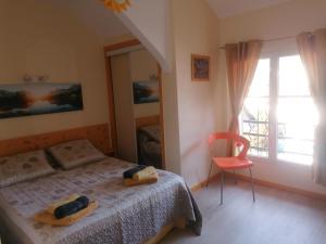 a bedroom with a bed and a chair and a window at Chambres d'hôtes L'Astazou in Gavarnie