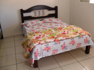 een slaapkamer met een bed met een bloemenbed bij POUSADA RECANTO DO TRABALHADOR in Rancharia