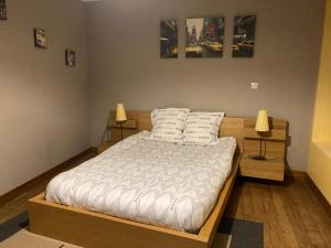 una camera da letto con un letto con due cuscini sopra di Le Logis de Pélagie a Neufchâtel-en-Bray