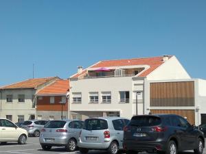 un grupo de autos estacionados en un estacionamiento en Aguda Beachfront Apartment, en Aguda