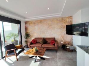 a living room with a couch and a table at Exclusive modern Villa with private pool in Los Montesinos