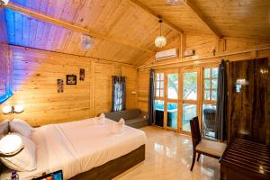 um quarto com uma cama num quarto de madeira em orange sky beach bungalow em Agonda