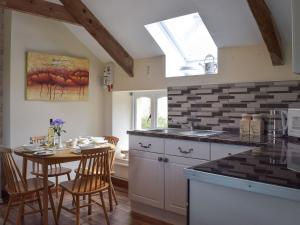 a kitchen with a table and chairs and a window at Upper Mill Barn in Nantgaredig