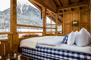 a bed in a room with a view of a mountain at Berghotel Rehlegg in Ramsau
