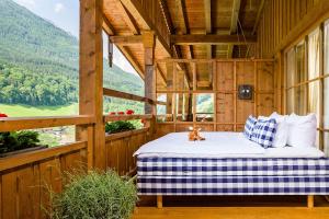 a bed in a wooden room with a window at Berghotel Rehlegg in Ramsau