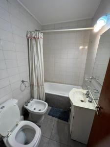 a bathroom with a toilet and a sink and a tub at temporario la plata centro balcon al frente in La Plata