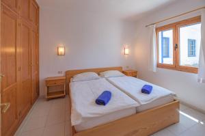 Un dormitorio con una cama con almohadas azules. en NUDIST Castillo de Papagayo, en Charco del Palo