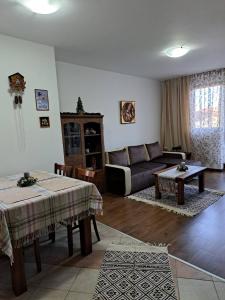 una sala de estar con un sofá y una mesa en Winslow Highland Bansko - Apartment Giovanni, ул Валевица 7 кв Грамадето, en Bansko