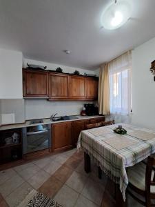 a kitchen with wooden cabinets and a table in it at Winslow Highland Bansko - Apartment Giovanni, ул Валевица 7 кв Грамадето in Bansko