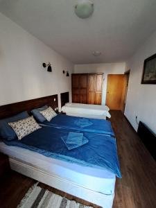 a bedroom with a large bed with blue sheets at Winslow Highland Bansko - Apartment Giovanni, ул Валевица 7 кв Грамадето in Bansko