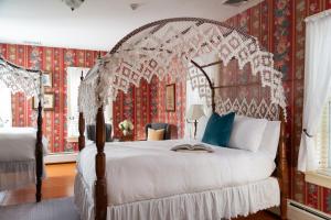 a bedroom with a canopy bed with red and white wallpaper at The Grafton Inn in Grafton