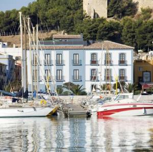 a group of boats docked in a harbor with a building at Hotel El Raset in Denia