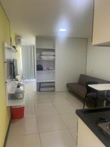 ein Wohnzimmer mit einem Sofa und einem TV in einem Zimmer in der Unterkunft Praia dos carneiros flat hotel in Tamandaré