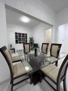 comedor con mesa de cristal y sillas en Departamento, en Ciudad de México