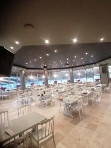 Safir Hotels Silivri في سيليفري: غرفة طعام كبيرة مع طاولات وكراسي بيضاء