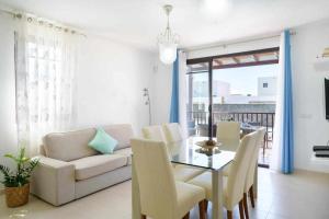 uma sala de estar com um sofá, uma mesa e cadeiras em Villa Aguamarina em Playa Blanca