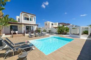 a villa with a swimming pool in front of a house at Villa Aguamarina in Playa Blanca