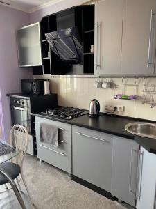 a kitchen with white cabinets and a stove top oven at 5й Зарічній 44 in Kryvyi Rih +4 photos