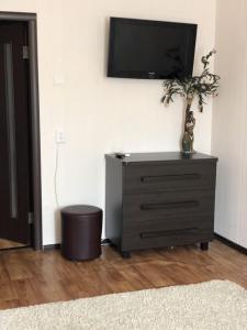 a room with a dresser with a tv on a wall at 5й Зарічній 44 in Kryvyi Rih