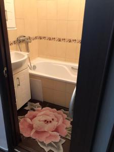 a bathroom with a tub and a pink flower on the floor at 5й Зарічній 44 in Kryvyi Rih