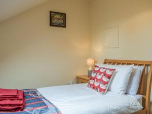 a bedroom with a bed with white sheets and pillows at Merry in Much Dewchurch