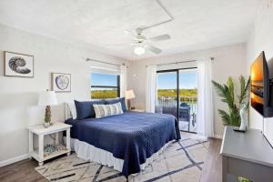 a bedroom with a blue bed and a balcony at Bayshore Yacht & Tennis 409 - Premier in Clearwater Beach