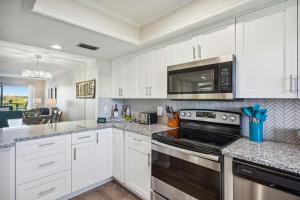 a kitchen with white cabinets and a black stove top oven at Bayshore Yacht & Tennis 409 - Premier in Clearwater Beach