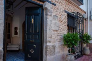 a black door on a brick building with a plant at Casas Rurales La Rinconá in Moral de Calatrava