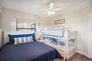 a bedroom with a bunk bed and a ceiling fan at Bayshore Yacht & Tennis 409 - Premier in Clearwater Beach