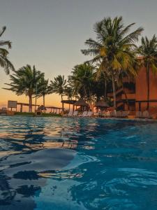 a swimming pool with palm trees and a resort at Reef Yucatán All Inclusive & Convention Center in Telchac Puerto