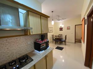 a kitchen and living room with a stove and a table at 3 Bed Apartment in Karachi