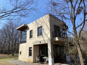 a woman sits in front of a house at Huna House in Thorndale