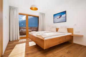 - une chambre avec un lit et une grande fenêtre dans l'établissement Exklusives Chalet mit Gletscherblick, à Neukirchen am Großvenediger