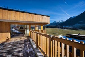 a house with a deck with mountains in the background at Exklusives Chalet mit Gletscherblick in Neukirchen am Großvenediger