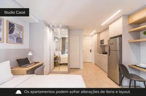 a bedroom with a bed and a desk with a laptop at Smart Charlie Mobi Pinheiros in Sao Paulo