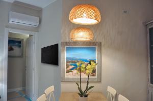 comedor con mesa y 2 luces en Villa Aquamarina Pavoncella Rossa en Porto Pino