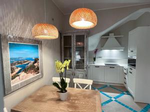 una cucina con due luci e un tavolo con fiori di Villa Aquamarina Pavoncella Rossa a Porto Pino