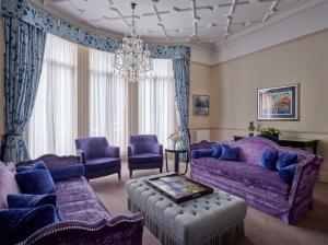 ロンドンにあるThe Apartments by The Sloane Clubの紫色の家具とシャンデリアが備わるリビングルーム