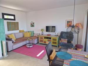 sala de estar con sofá y TV en Las Pardelas, Ferienhaus mit Meer-, Küsten- und Bergblick im grünen Norden Teneriffas, en Las Cruces
