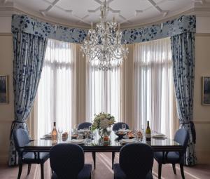 a dining room with a table and chairs and a chandelier at The Apartments by The Sloane Club in London