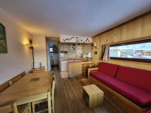 a living room with a red couch and a kitchen at Appartement Tignes, 2 pièces, 5 personnes - FR-1-449-23 in Tignes