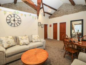 a living room with a couch and a clock on the wall at Howard's Hideaway in Hayfield