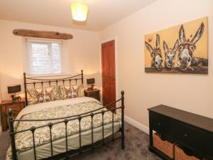 a bedroom with a bed and a picture of animals on the wall at Howard's Hideaway in Hayfield