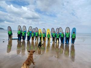 a group of people standing on the beach with their surfboards at 4 Rockham - Luxury Apartment at Byron Woolacombe, only 4 minute walk to Woolacombe Beach! in Woolacombe