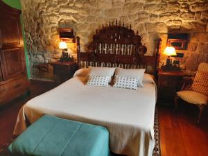 a bedroom with a large bed and a stone wall at Hotel Castillo El Collado in Laguardia