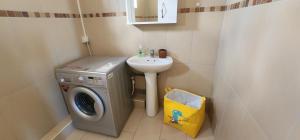 een kleine badkamer met een wasmachine en een wastafel bij Peaceful holidays in Pereybere in Pereybere
