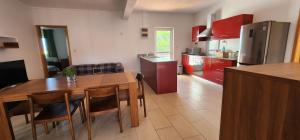 una cocina con mesa de madera y una cocina con armarios rojos. en Peaceful holidays in Pereybere, en Pereybere