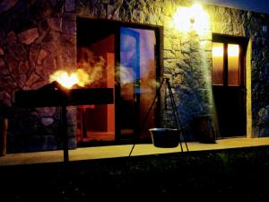 a fire in front of a stone building at night at house s&d in Otočac