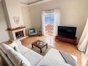 ein Wohnzimmer mit einem weißen Sofa und einem TV in der Unterkunft Ocean 59 by LovelyStay in Funchal